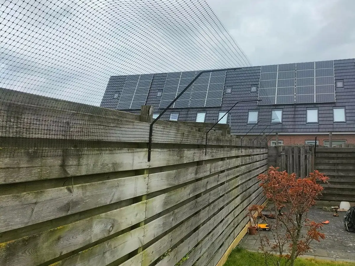 Kattennet met insteekbeugels op houten schutting in achtertuin